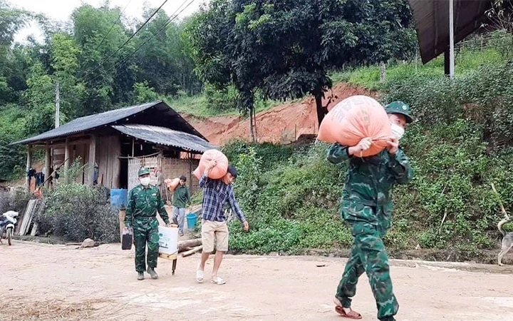 Bộ đội Biên phòng Na Mèo giúp người dân di chuyển khỏi khu vực sạt lở đất.