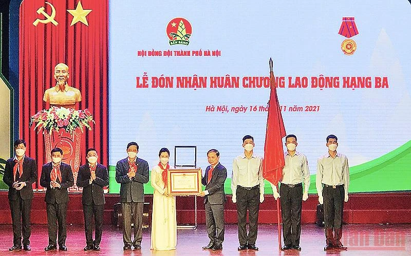 Đồng chí Phạm Tất Thắng (thứ tư từ bên phải sang trong ảnh) thừa ủy quyền của Chủ tịch nước, trao Huân chương Lao động hạng ba tặng Hội đồng Đội thành phố Hà Nội. 