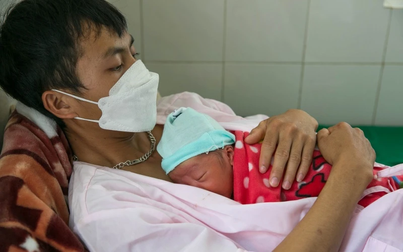 Anh Mùa A Nhìa, người dân tộc H'mông, 21 tuổi, thực hiện phương pháp da kề da với con trai sinh non tại phòng Kangaroo, Bệnh viện đa khoa tỉnh Điện Biên.