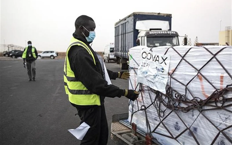 Nhân viên bốc dỡ một lô vaccine ngừa Covid-19 của hãng AstraZeneca/Oxford, được viện trợ theo chương trình COVAX, tại Dakar (Senegal) hồi tháng 3/2021. (Ảnh: AFP/TTXVN)
