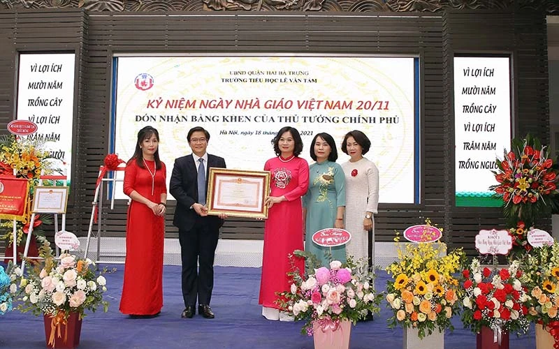 Đại diện Bộ Giáo dục và Đào tạo thừa ủy quyền của Thủ tướng Chính phủ trao Bằng khen cho tập thể cán bộ giáo viên Trường tiểu học Lê Văn Tám.