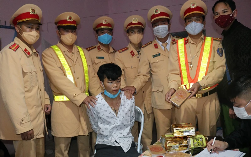 Tòng Văn Dính cùng tang vật khi bị lực lượng Cảnh sát giao thông Công an tỉnh Điện Biên bắt giữ.