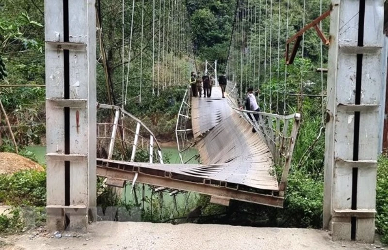 Cầu treo Nam Quang bị đứt gãy làm xe tải chở hàng rơi xuống sông. (Ảnh: TTXVN)