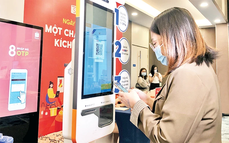 Người tiêu dùng Hà Nội thử nghiệm quét mã QR để thanh toán trực tuyến.