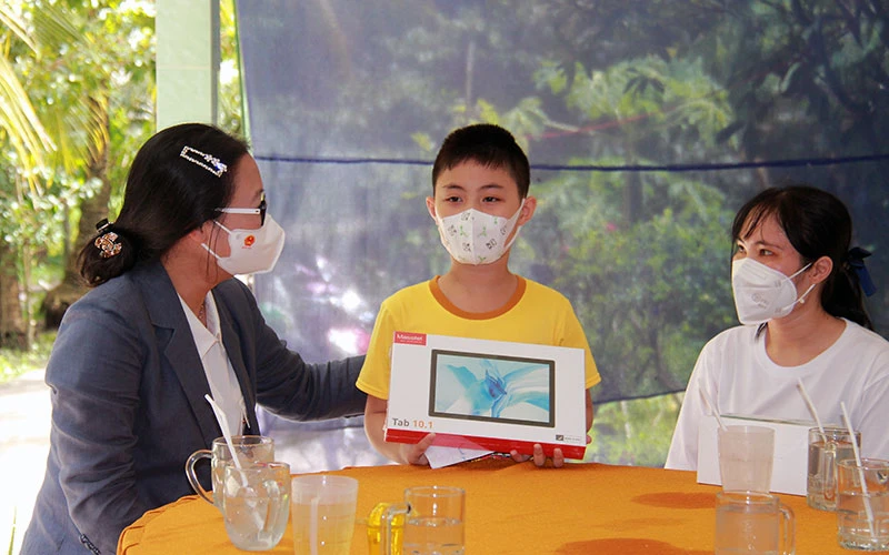 Lãnh đạo tỉnh Vĩnh Long thăm và trao máy tính bảng tặng trẻ mồ côi vì Covid-19 ở huyện Vũng Liêm. Ảnh: BÁ DŨNG 