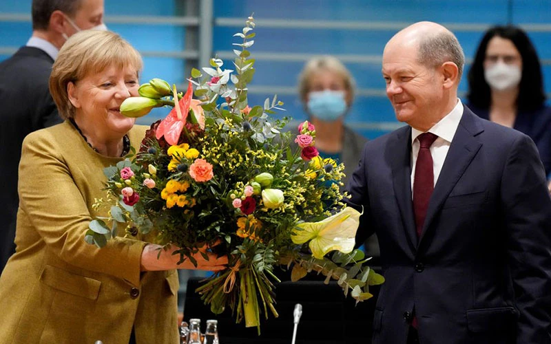 Ông Olaf Scholz tặng hoa cho bà Angela Merkel trước cuộc họp của nội các Đức, ngày 24/11. (Ảnh: Reuters)