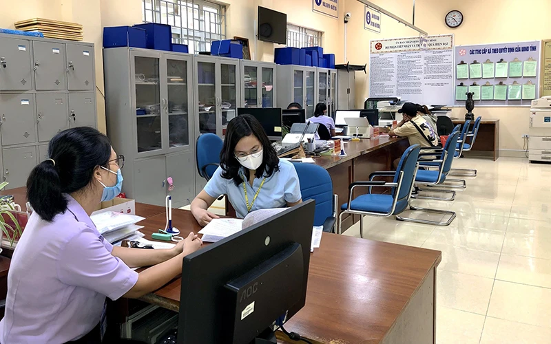 Công chức xã Quảng Tân (huyện Ðầm Hà, Quảng Ninh) hướng dẫn người dân giải quyết thủ tục hành chính tại trụ sở.