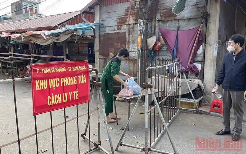 Người dân nhận nhu yếu phẩm trong khu cách ly ở chợ Phụ Long, phường Trần Tế Xương, thành phố Nam Định.