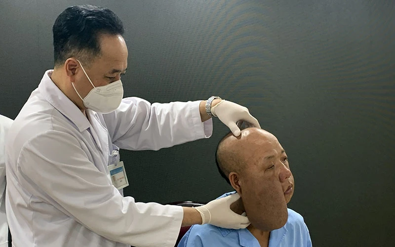 PGS, TS Trần Cao Bính, Giám đốc Bệnh viện Răng Hàm mặt Trung ương thăm khám cho bệnh nhân trước khi phẫu thuật.