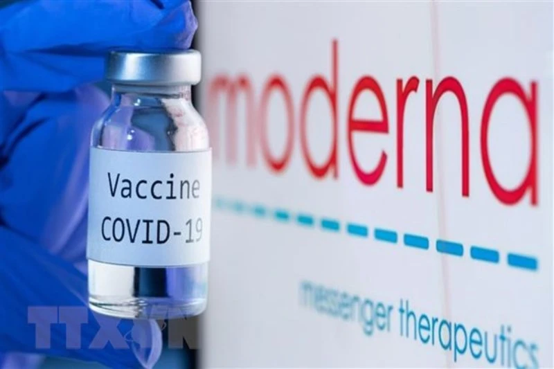 Vaccine ngừa Covid-19 bên biểu tượng của hãng dược phẩm Moderna. (Ảnh: AFP/TTXVN)