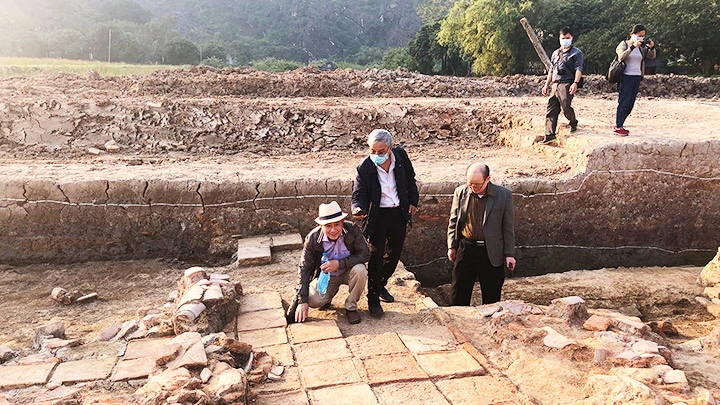 Khảo sát nền gạch tại cấp nền kiến trúc thời Tiền Lê trong khu vực hố khai quật tại cố đô Hoa Lư. Ảnh: VŨ ANH