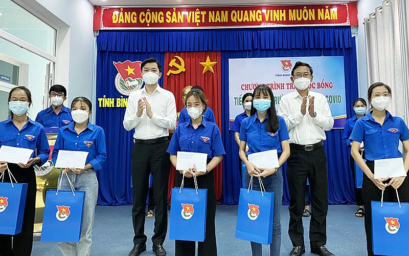 Đồng chí Nguyễn Minh Triết (áo trắng, bên trái trong ảnh) cùng đại diện lãnh đạo tỉnh Bình Định trao học bổng tặng học sinh, sinh viên tại chương trình.