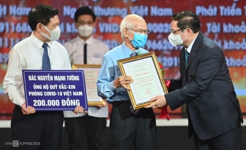 Thủ tướng Chính phủ Phạm Minh Chính trao chứng nhận, hoa cảm ơn bác Nguyễn Mạnh Tường 82 tuổi, cán bộ hưu trí ngành đường sắt đã đóng góp cho Quỹ vaccine phòng Covid-19.