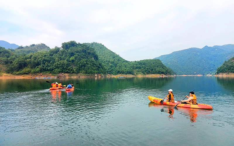 Du khách trải nghiệm chèo thuyền kayak trên hồ Hòa Bình. 