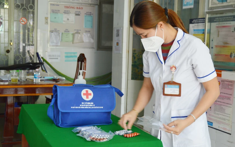 Nhân viên y tế xã Bình Thành, huyện Thanh Bình, Đồng Tháp chuẩn bị túi thuốc cho F0 điều trị tại nhà.