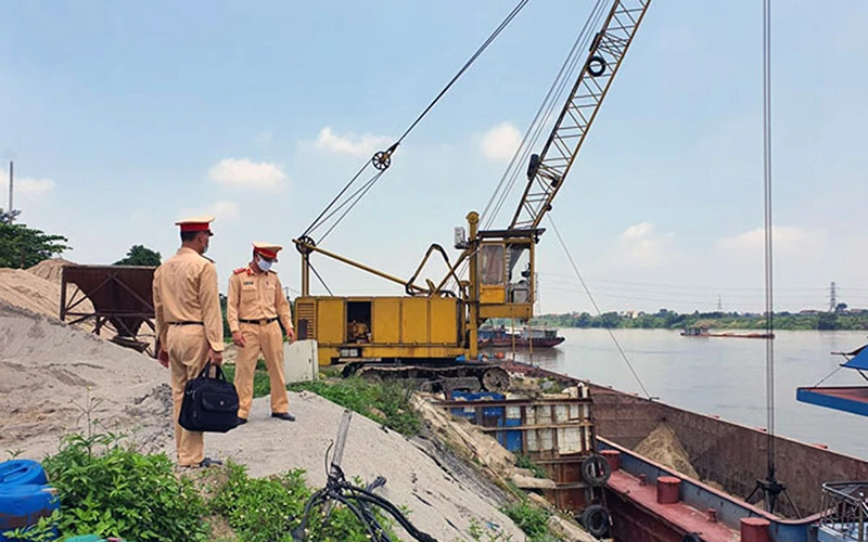 Lực lượng Cảnh sát giao thông đường thủy (Công an thành phố Hà Nội) kiểm tra một bến tập kết vật liệu xây dựng hoạt động không phép ven sông Hồng tại xã Thống Nhất (huyện Thường Tín, Hà Nội). Ảnh: CHU DŨNG 