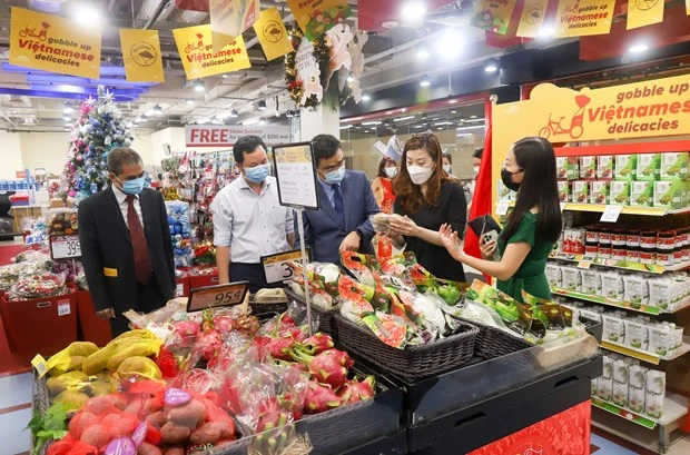 Bà Goh Tsu Ching (thứ 2, từ phải sang), Giám đốc cung ứng quốc tế FairPrice, giới thiệu các mặt hàng trưng bày tại Tuần lễ hàng Việt Nam. (Ảnh: TTXVN)