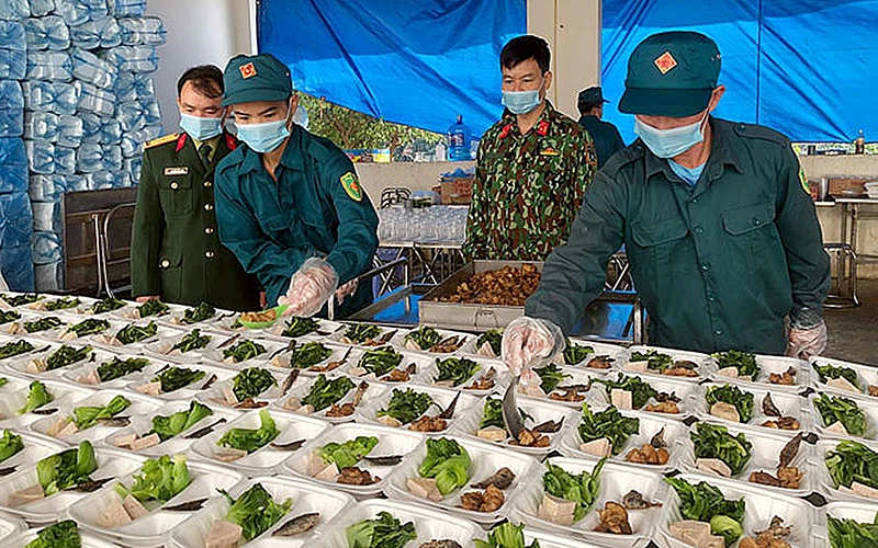 Các chiến sĩ dân quân tự vệ chuẩn bị bữa ăn hằng ngày cho công dân trong Khu cách ly số 6 tại Trung tâm Huấn luyện và bồi dưỡng nghiệp vụ Công an tỉnh Yên Bái. Ảnh: Thanh Chi