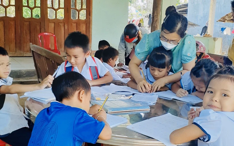 Cô giáo Trường tiểu học Thanh An hướng dẫn học sinh tại các điểm trường trong thôn. 