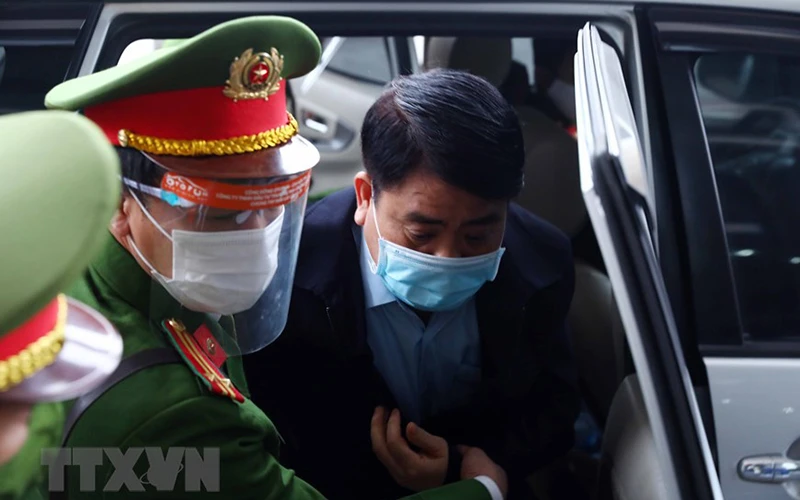 Bị cáo Nguyễn Đức Chung (cựu Chủ tịch Ủy ban Nhân dân thành phố Hà Nội) được lực lượng chức năng dẫn giải đến phiên tòa. (Ảnh: TTXVN)