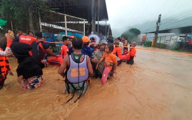 Nhân viên Lực lượng Bảo vệ bờ biển Philippines hỗ trợ sơ tán người dân rời khỏi khu vực bị ngập lụt do bão Rai tại thành phố Cagayan De Oro, ngày 16/12. (Ảnh: Reuters)