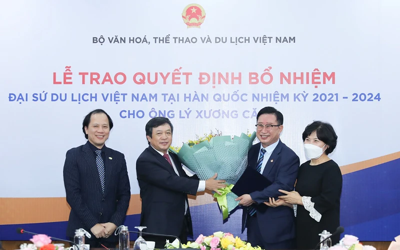 Thứ trưởng Đoàn Văn Việt (bên trái) trao hoa và Quyết định bổ nhiệm Đại sứ Du lịch Việt Nam tại Hàn Quốc cho ông Lý Xương Căn (phải) (Ảnh: NGUYỄN NAM)