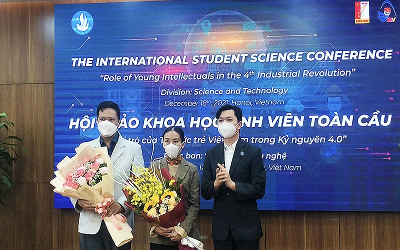 Đồng chí Nguyễn Minh Triết (bên phải trong ảnh) trao hoa tặng các đại biểu trí thức trẻ tham gia Hội thảo tại đầu cầu thành phố Hà Nội.
