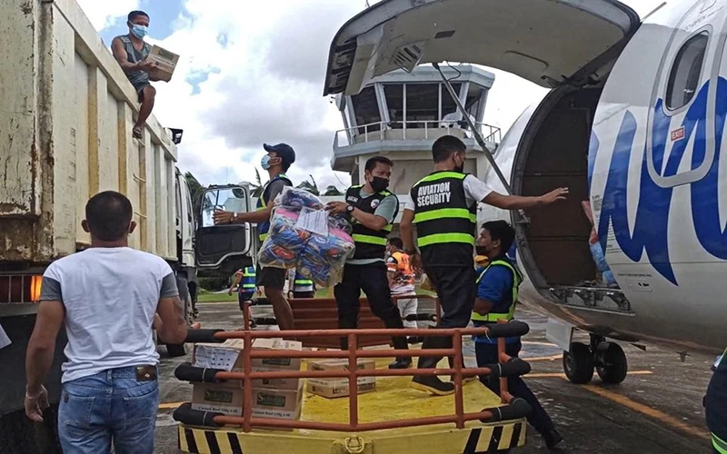 Nhân viên hàng không hỗ trợ dỡ hàng viện trợ cho nạn nhân của bão Rai tại tỉnh Surigao del Norte, Philippines. (Ảnh: Lực lượng Bảo vệ bờ biển Philippines/Reuters)