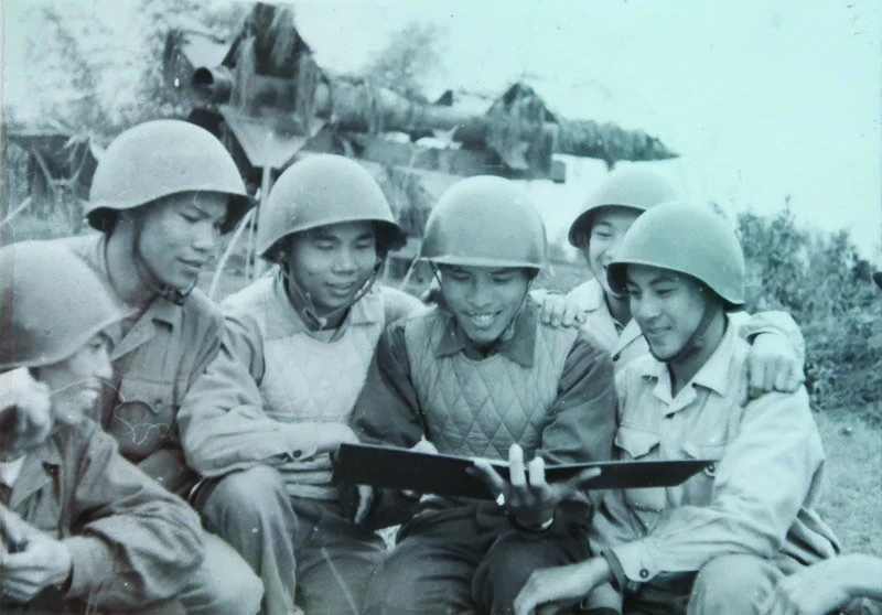 Ông Nguyễn Quang Hùng (ngồi giữa, tay cầm sổ rút kinh nghiệm chiến đấu) khi còn là sĩ quan điều khiển cùng với kíp chiến đấu Tiểu đoàn 62 tại trận địa Cổ Nhuế, Hà Nội, năm 1967. (Ảnh: nhân vật cung cấp)