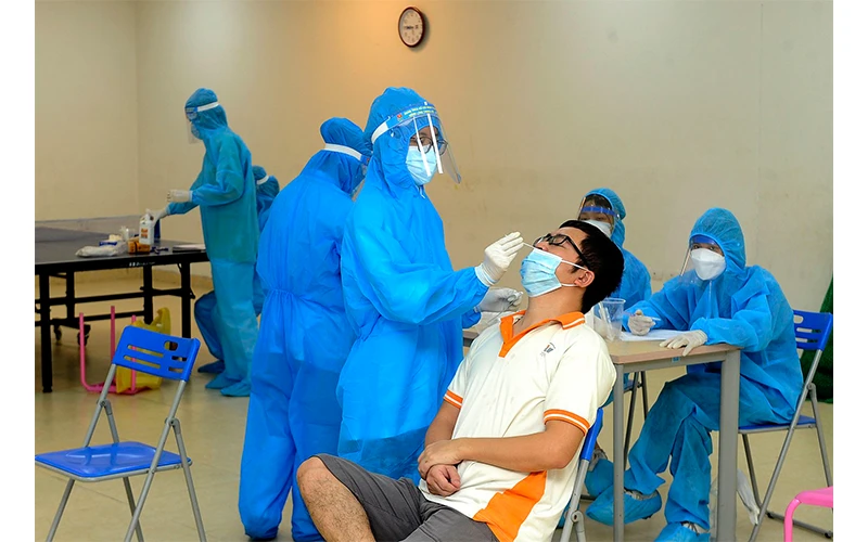 Nhân viên Trạm Y tế phường Vĩnh Hưng, quận Hoàng Mai (Hà Nội) lấy mẫu xét nghiệm Covid-19 cho người dân tổ 32. Ảnh: Anh Sơn