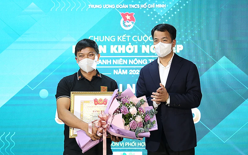 Tác giả dự án “Nông trại Cờ Đỏ”, anh Lương Văn Trường (bên trái trong ảnh) nhận giải nhất Cuộc thi “Dự án khỏi nghiệp thanh niên nông thôn” năm 2021.