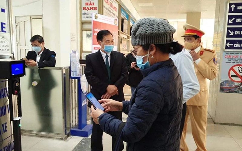 Lực lượng Cảnh sát giao thông Hà Nội hướng dẫn người dân thao tác quét mã QR để khai báo y tế ở bến xe.