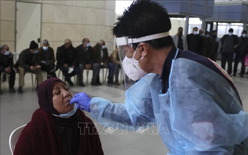Nhân viên y tế lấy mẫu xét nghiệm Covid-19 cho người dân Palestine tại Dải Gaza ngày 20/12. (Ảnh: TTXVN)