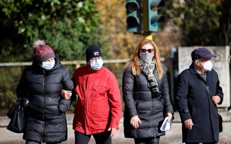 Người dân đeo khẩu trang đi bộ trên đường phố Rome, khi vùng Lazio ra quy định bắt buộc phải đeo khẩu trang ở tất cả các khu vực ngoài trời, Rome, Italia, ngày 23/12/2021. (Ảnh: Reuters)
