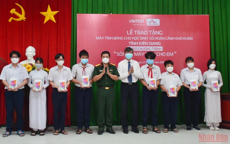 Ông Nguyễn Lưu Trung, Phó Chủ tịch UBND tỉnh Kiên Giang (thứ 5 từ phải sang) trao tặng máy tính bảng cho đại diện các em học sinh.