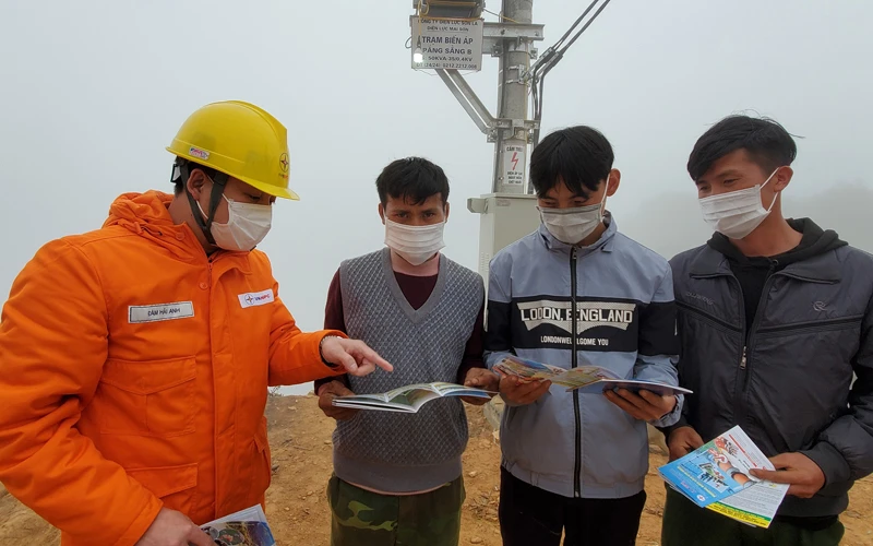 Cán bộ Điện lực Sơn La hướng dẫn người dân xã Chiềng Kheo cách sử dụng điện tiết kiệm.