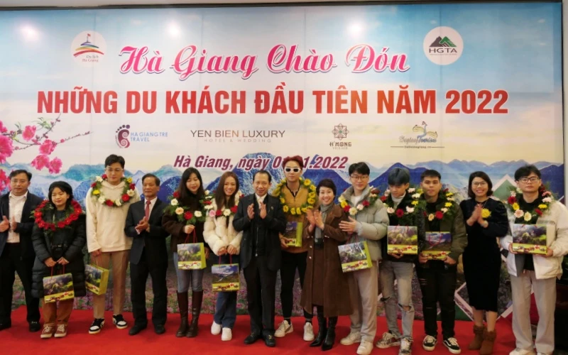 Lãnh đạo tỉnh Hà Giang tặng hoa và quà chúc mừng những vị khách đầu tiên.