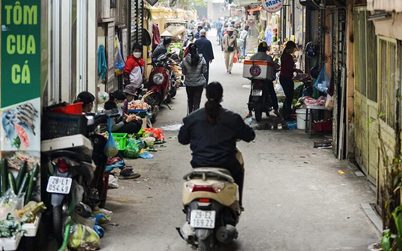 Quận Đống Đa (TP Hà Nội) đã ra thông báo cấm chợ cóc, chợ tạm... song hoạt động buôn bán vẫn nhộn nhịp tại phố Vũ Thạnh. Ảnh: Ngô Nhung