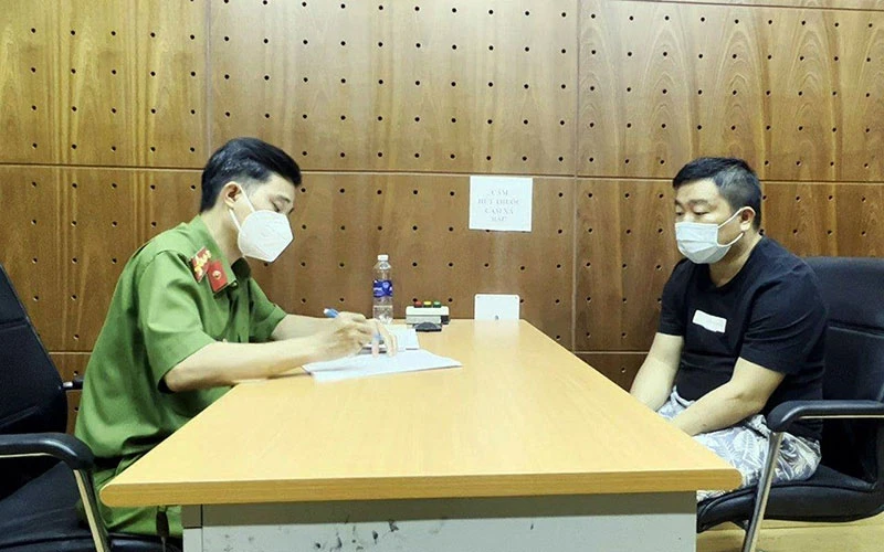 Ðối tượng Trần Minh Tuấn (bên phải) tại Cơ quan cảnh sát điều tra Công an thành phố Hồ Chí Minh. Ảnh: LÊ NGỌC 