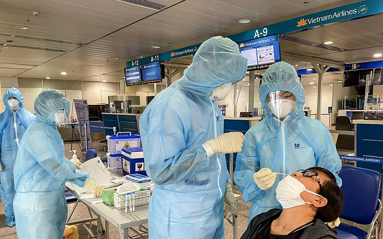 Nhân viên y tế xét nghiệm nhanh Covid-19 cho hành khách tại khu vực sân bay Tân Sơn Nhất (TP Hồ Chí Minh). Ảnh: VNVC