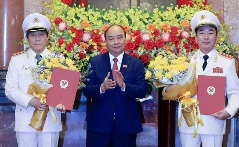 Chủ tịch nước Nguyễn Xuân Phúc trao Quyết định thăng cấp bậc hàm từ Trung tướng lên Thượng tướng đối với Thứ trưởng Công an Trần Quốc Tỏ và Lương Tam Quang. (Ảnh: Thống Nhất/TTXVN)