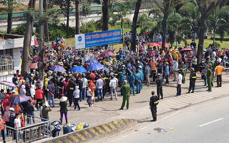 Lực lượng chức năng vận động người dân trở lại bên trong Công ty TNHH Pouchen Việt Nam.