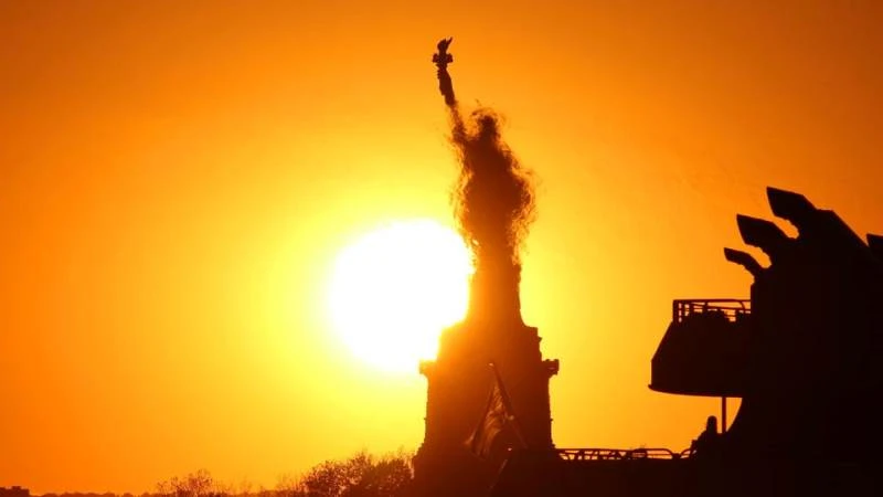 Mặt trời lặn đằng sau Tượng Nữ thần Tự do ở New York, Mỹ, tháng 5/2020. (Ảnh: AFP KEY FACTS)
