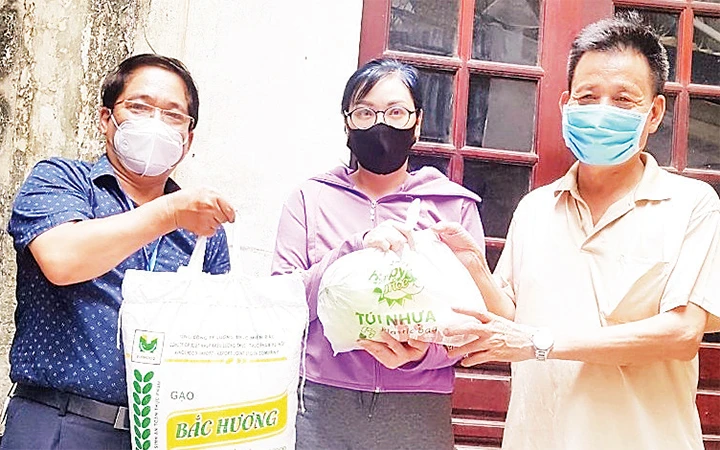 Ông Nguyễn Hữu Sinh (bên phải) tặng quà cho các hộ có hoàn cảnh khó khăn trên địa bàn trong thời gian xảy ra dịch bệnh.