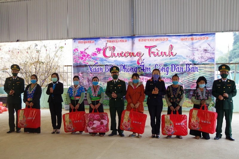 Đại diện Đảng ủy Bộ Chỉ huy Bộ đội Biên phòng tỉnh và lãnh đạo xã Mường Lạn tặng quà Tết cho các hộ gia đình nghèo bản Pu Hao.