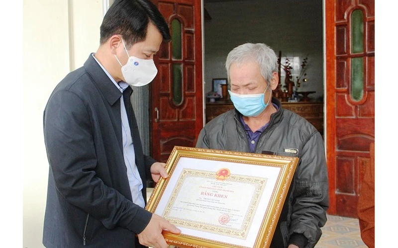 Trưởng Ban Tuyên giáo Tỉnh ủy Thanh Hóa trao Bằng khen cho đại diện gia đình anh Nam.