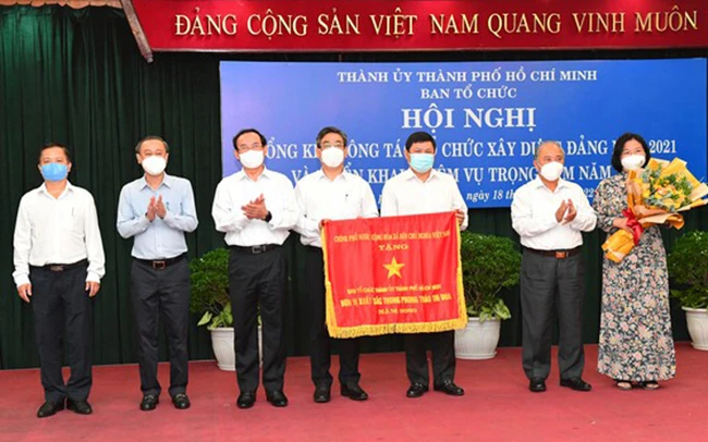 Đồng chí Nguyễn Văn Nên tặng cờ thi đua của Chính phủ cho Ban Tổ chức Thành ủy TP Hồ Chí Minh. (Ảnh: SGGP)