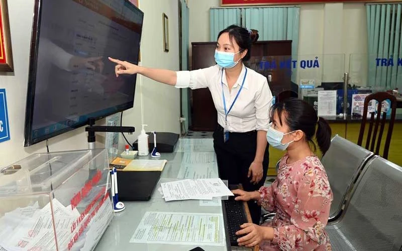 Hướng dẫn người dân thực hiện dịch vụ công trực tuyến tại phường Trung Hòa, quận Cầu Giấy, Hà Nội (Ảnh: DUY LINH)