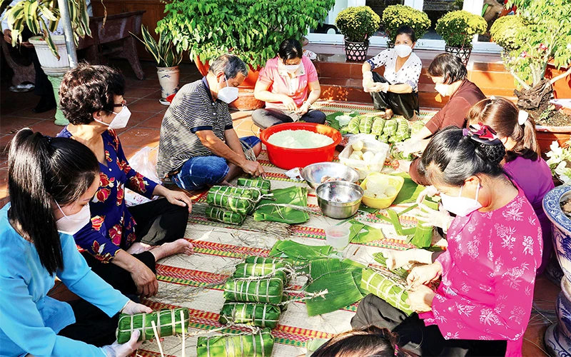 Bà Bùi Thị Bên tổ chức gói 50 cái bánh chưng, bánh tét và làm liên hoan tất niên cho công nhân nhà trọ.