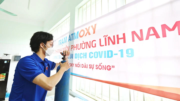 Tổ hỗ trợ theo dõi người nhiễm Covid-19 tại nhà, phường Lĩnh Nam, quận Hoàng Mai sẵn sàng mang bình oxy đến cho người bệnh. Ảnh: MINH QUYẾT (TTXVN)